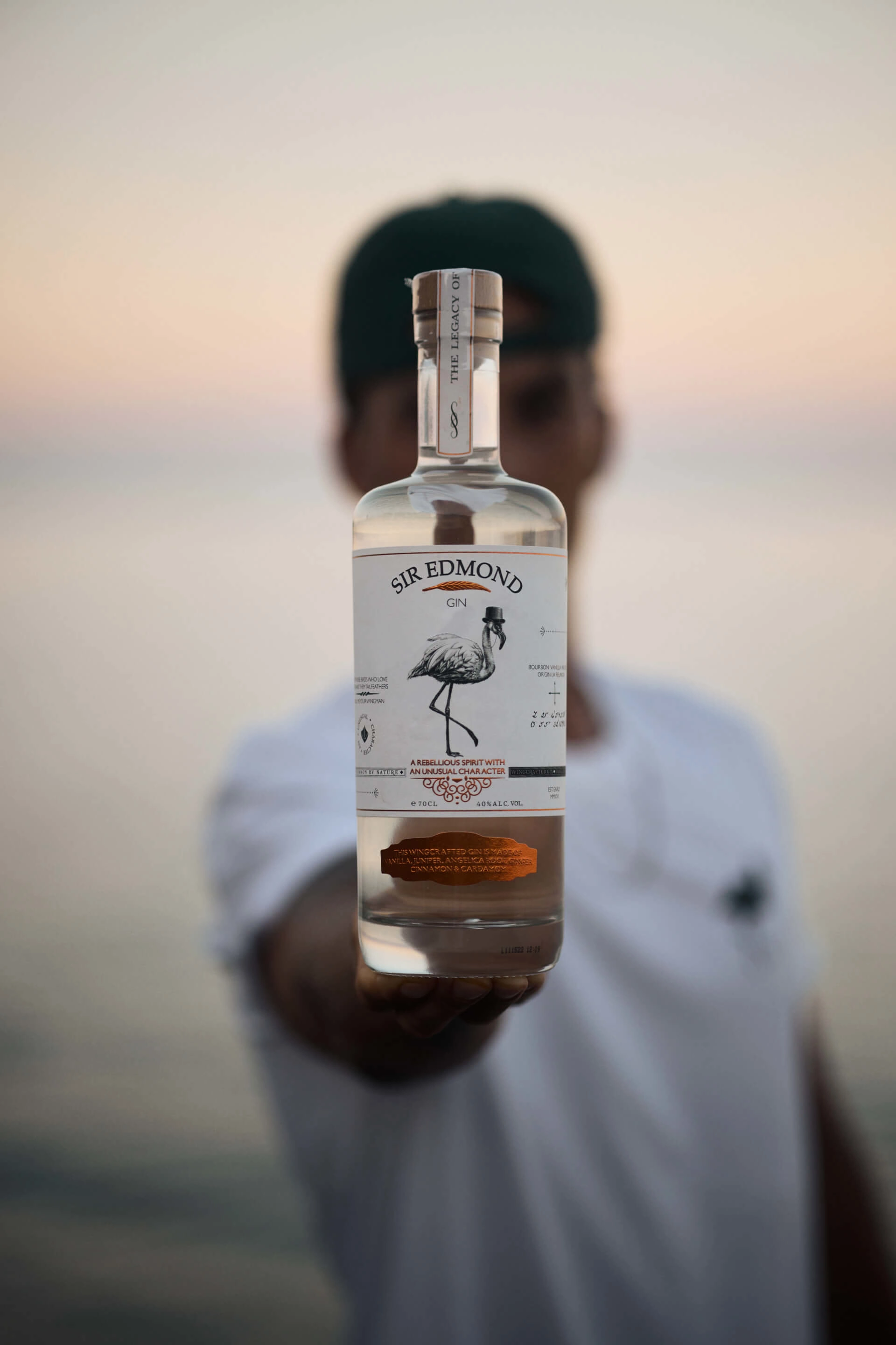 A bottle of Sir Edmond gin presented by a man.